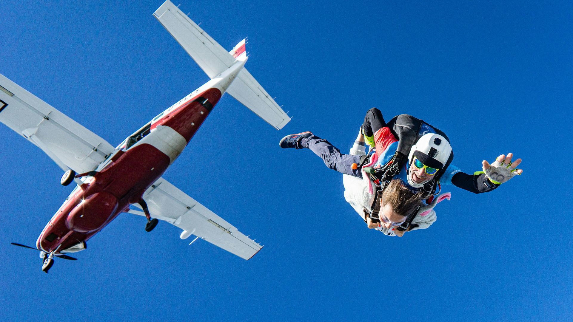 white and red airplane in mid air during daytime