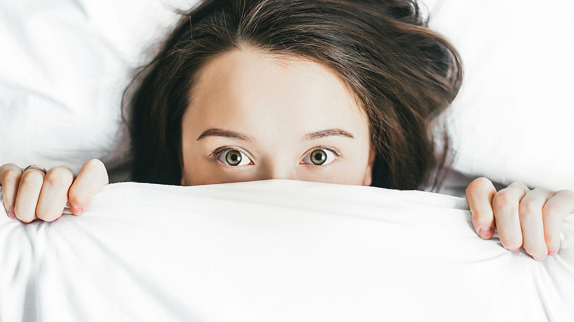 woman covering her face with blanket