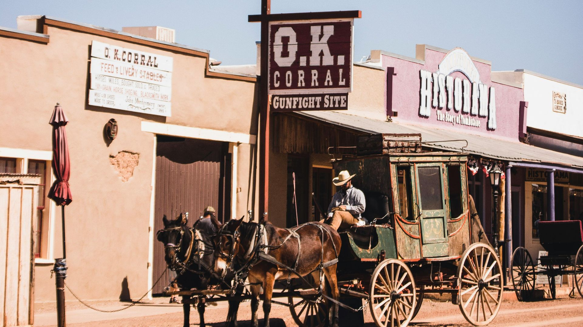 people riding horses in front of brown concrete building during daytime