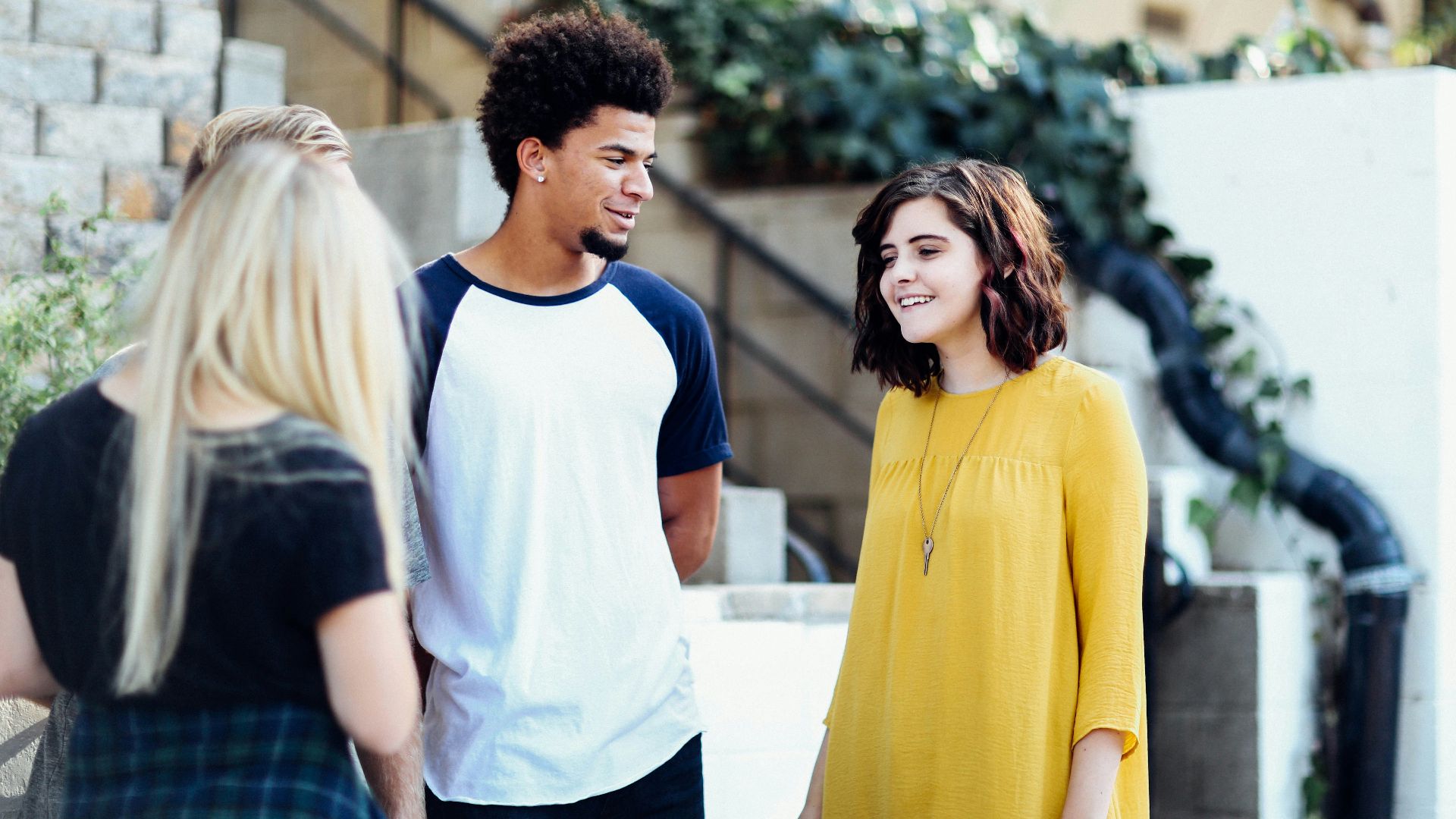 women and man talking outside the building
