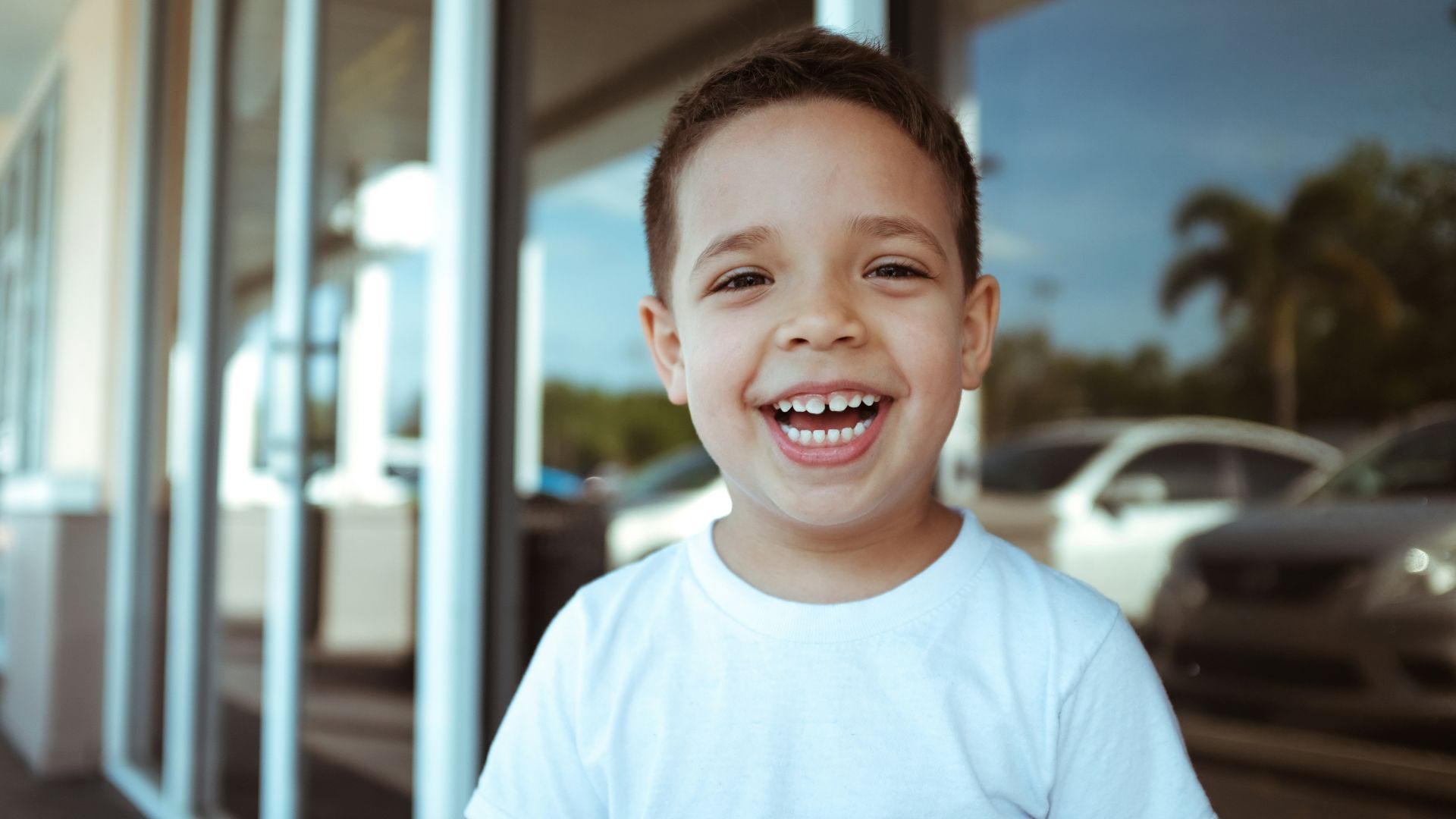 smiling boy wearing white crew-neck t-shirt during daytime