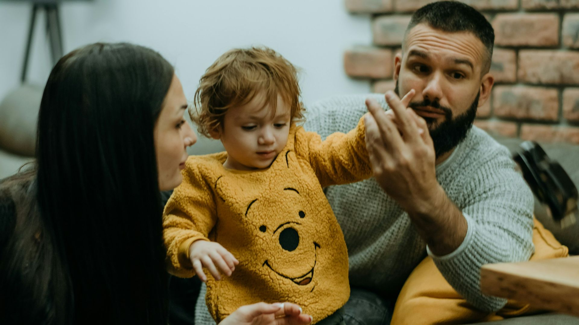 a man, woman and child sitting on a couch