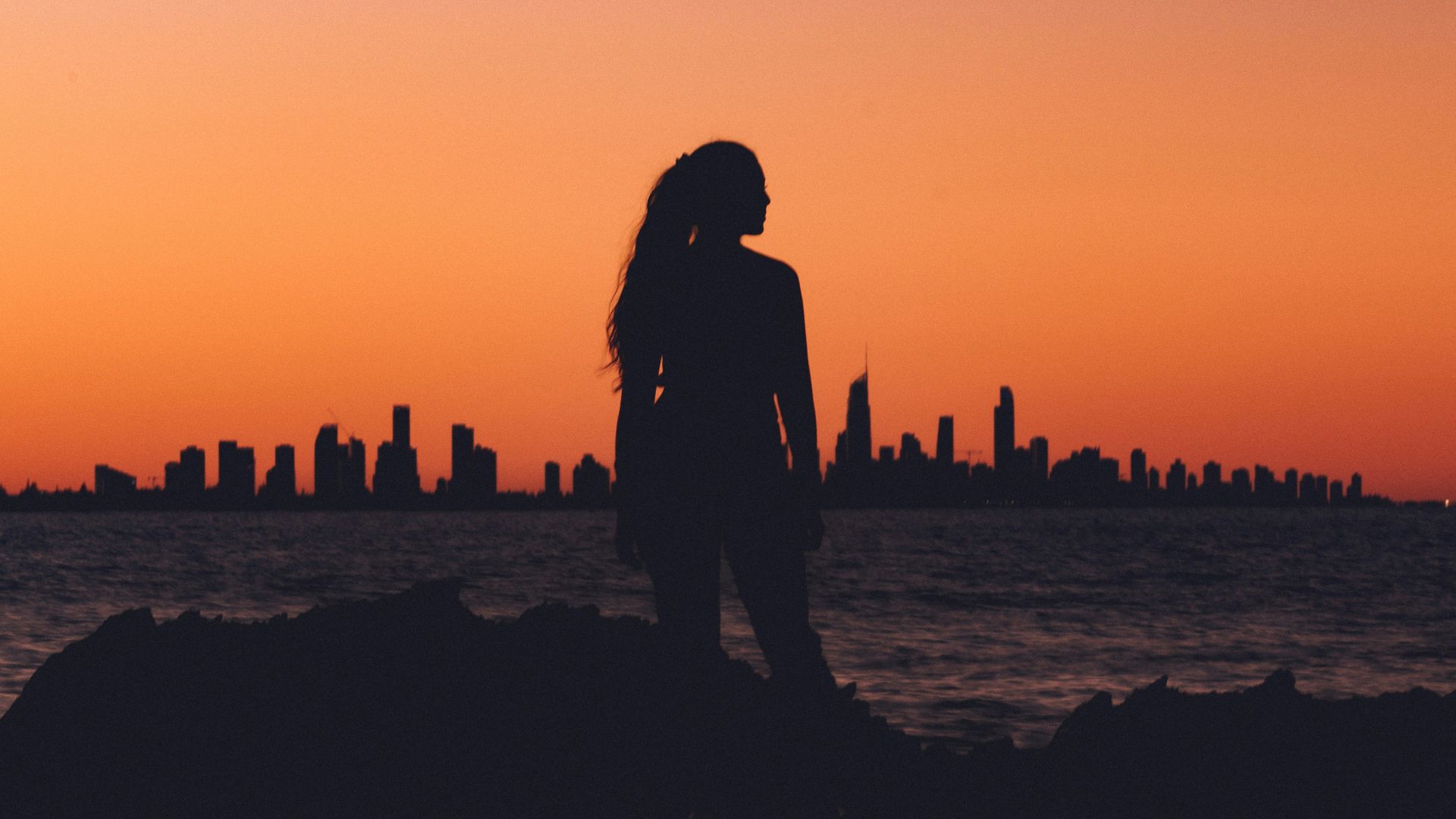 silhouette of woman near shoreline