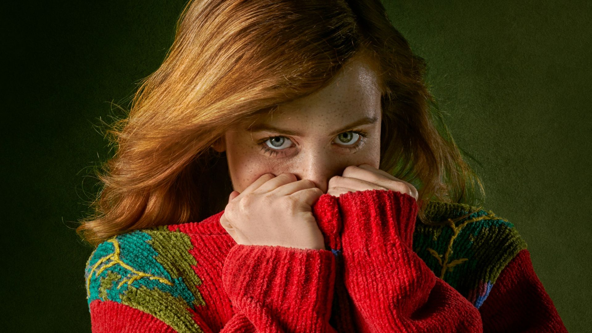 woman covering mouth with sweater