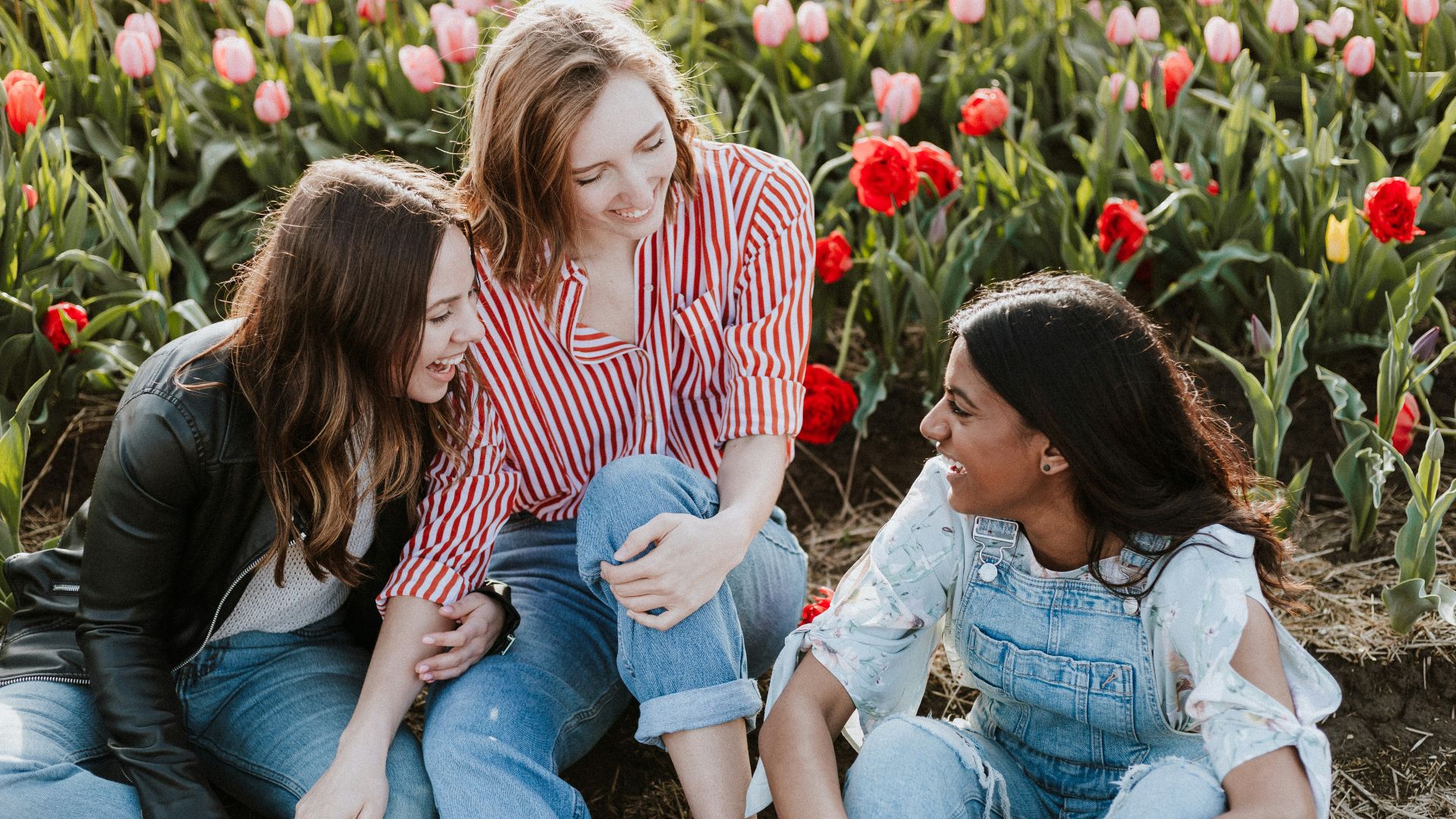 three woman sitting near the flower