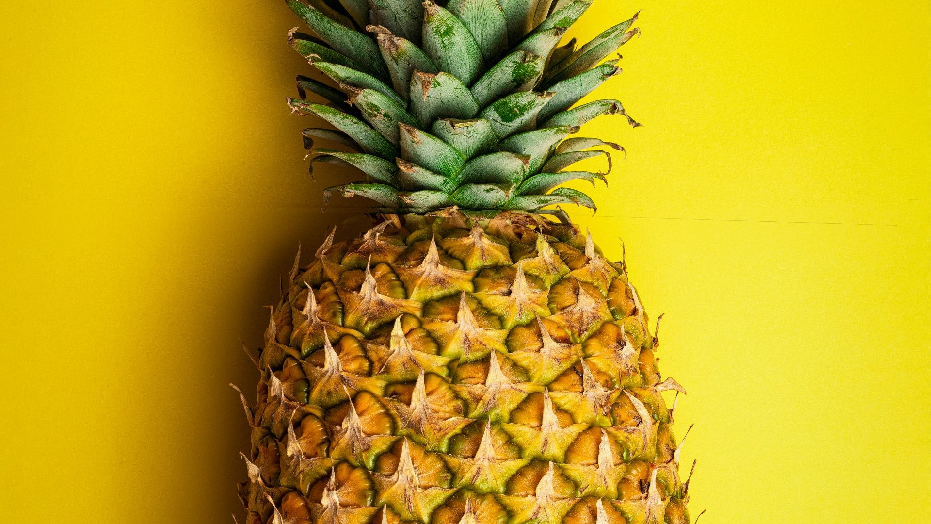 pineapple fruit on yellow surface