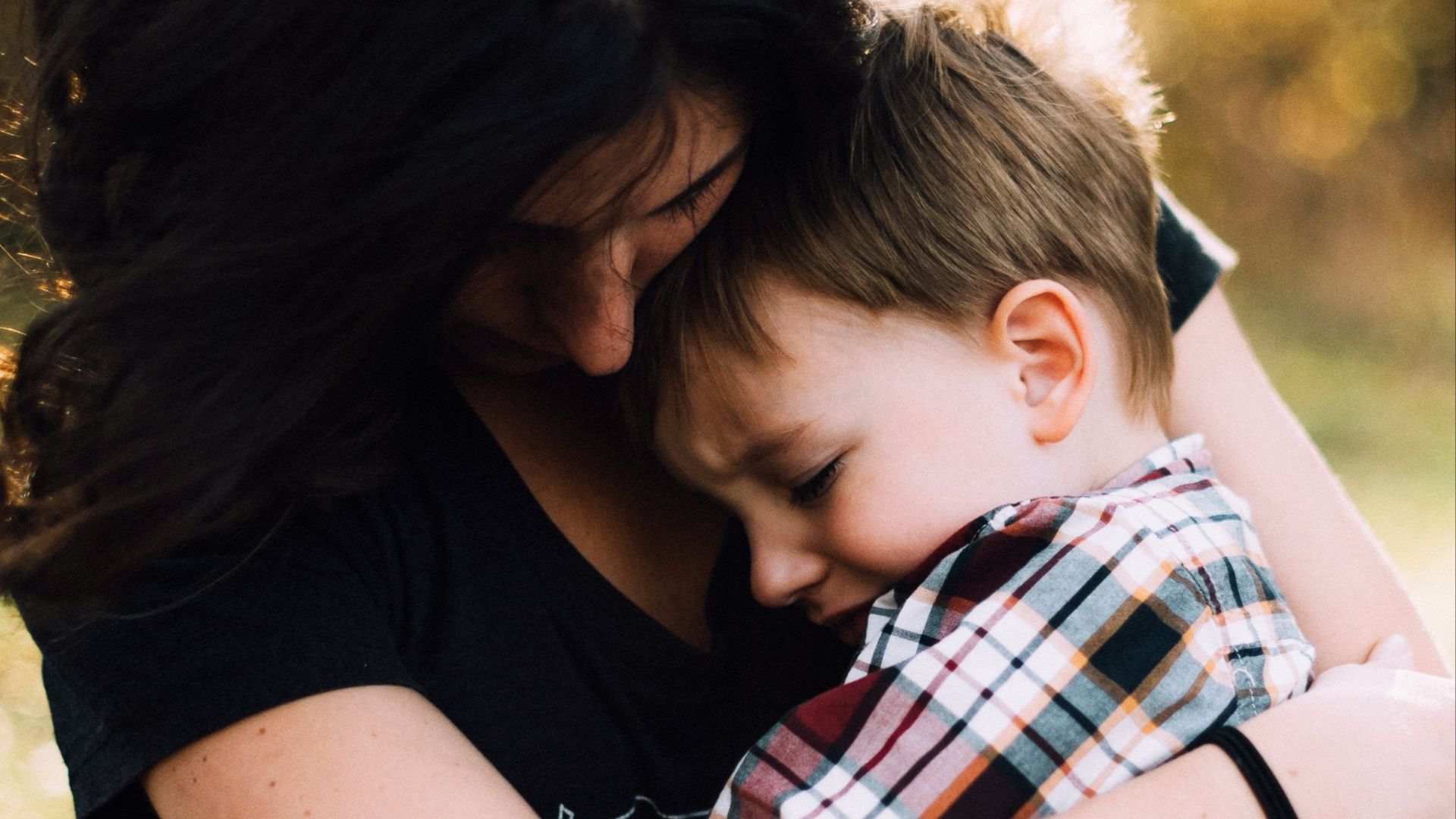 woman hugging boy on her lap