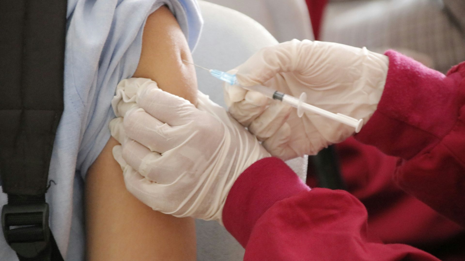 a person in a red shirt and white gloves