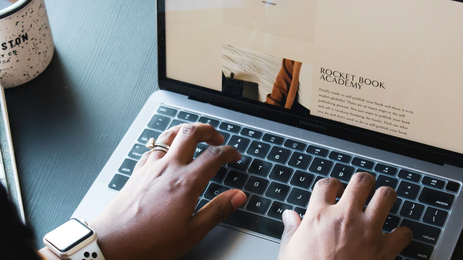 person using macbook pro on black table