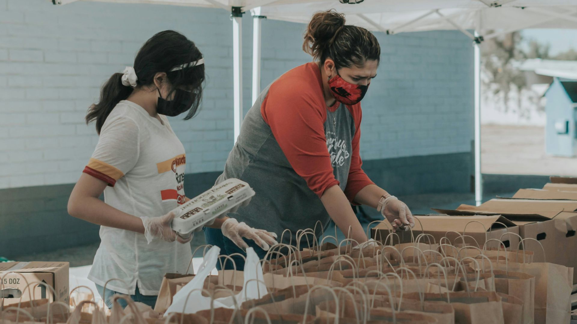 man in red t-shirt holding white plastic bottle