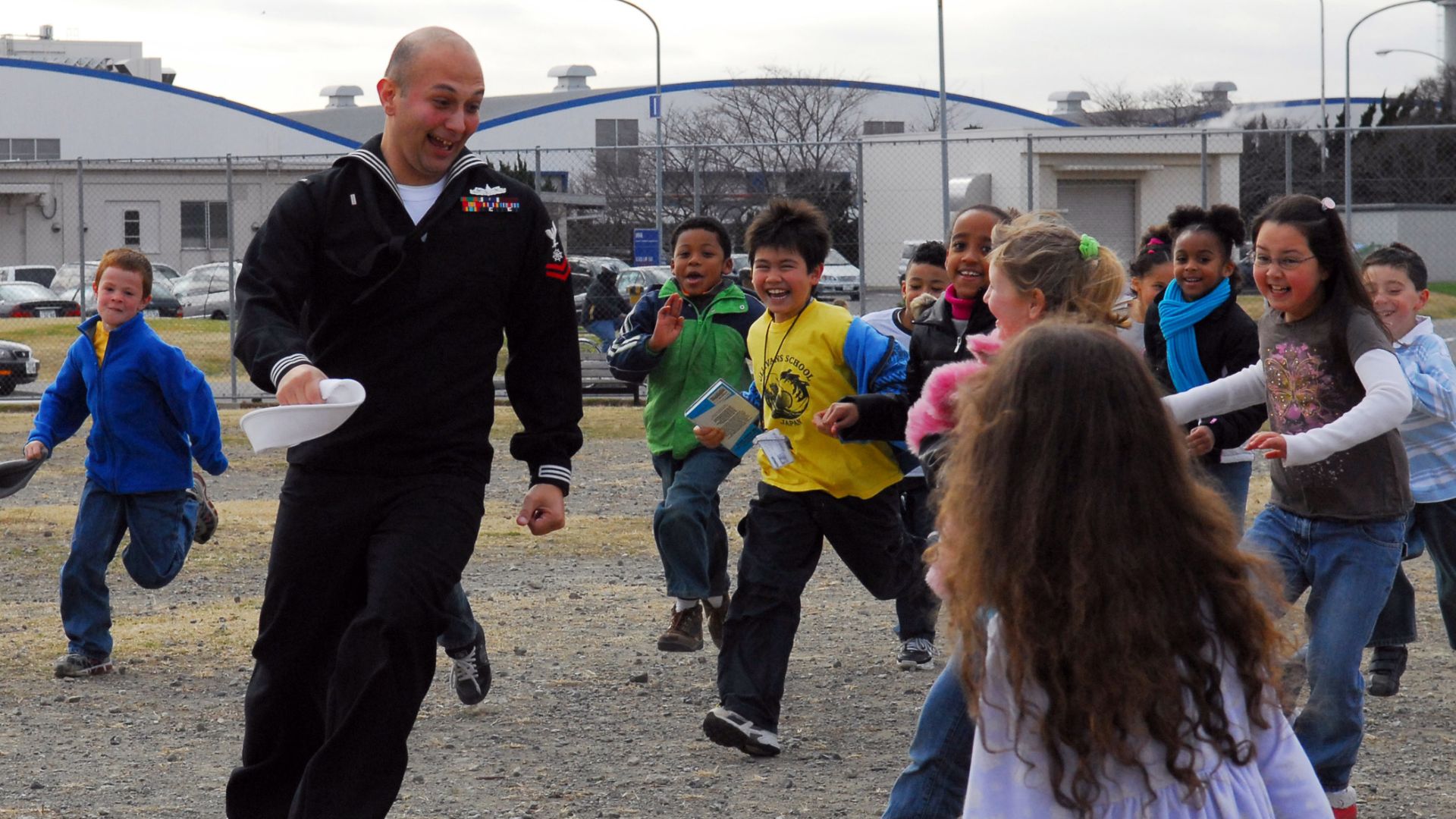 File:US Navy 090107-N-2013O-024 Quartermaster 2nd Class Aaron Martinez, assigned to the Arleigh-Burke class guided-missile destroyer USS The Sullivans (DDG 68), runs from students during a game of tag at The Sullivans Elementary Sch.jpg