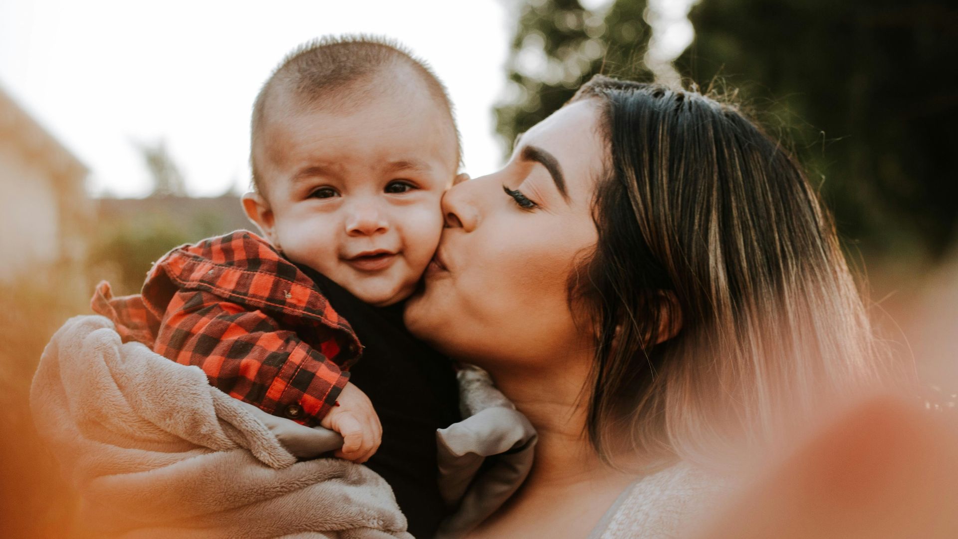 woman kiss a baby while taking picture