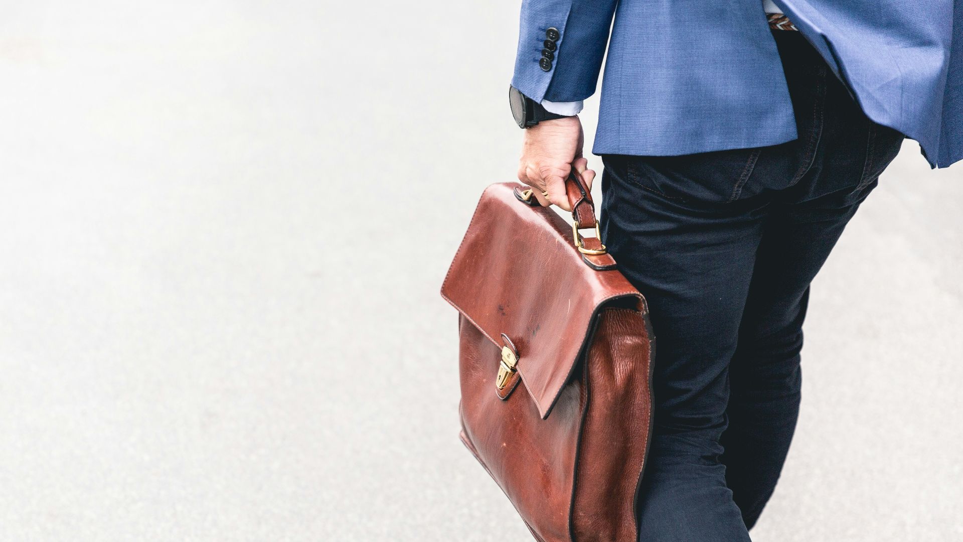 person walking holding brown leather bag