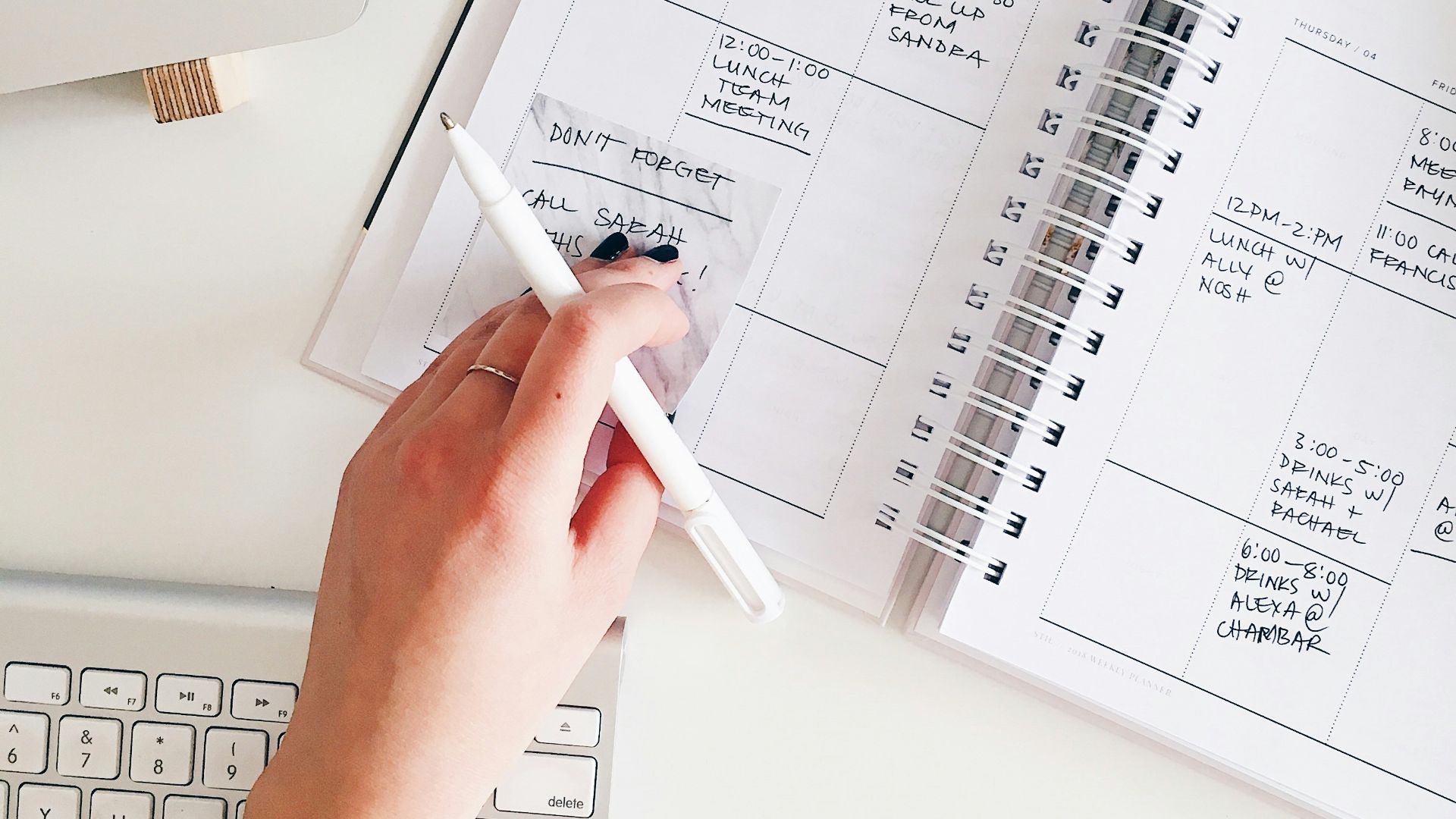 person holding notepad and pen flat lay photography