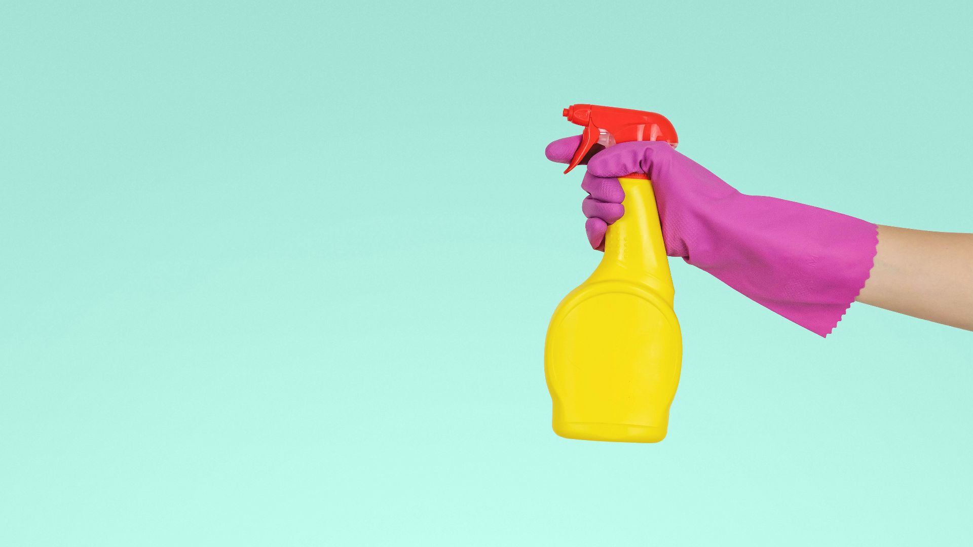 person holding yellow plastic spray bottle
