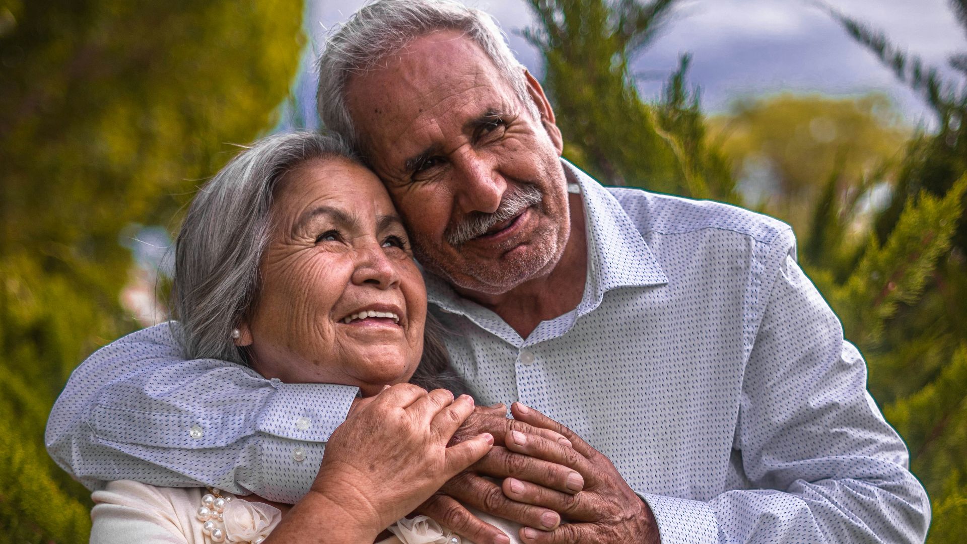 man in white dress shirt hugging woman in white dress