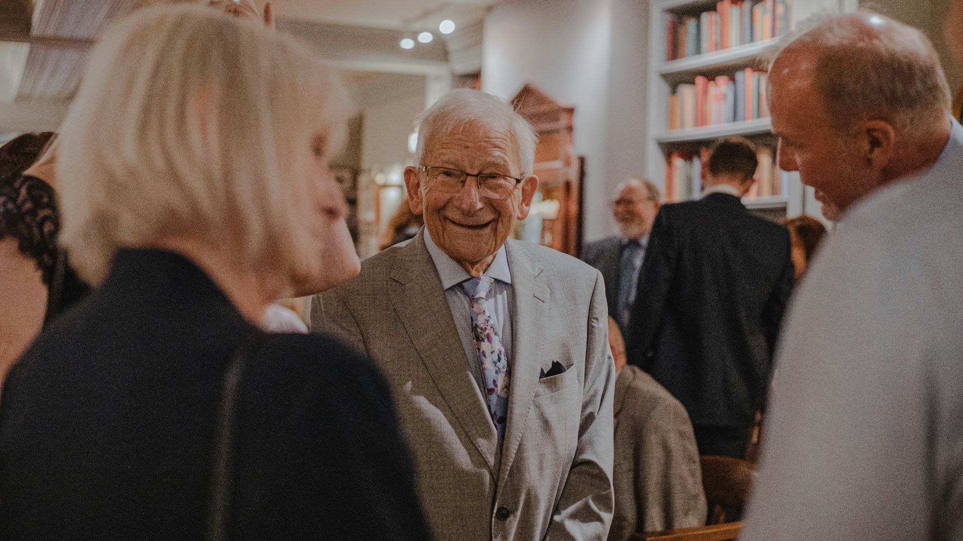 smiling man wearing suit standing beside man
