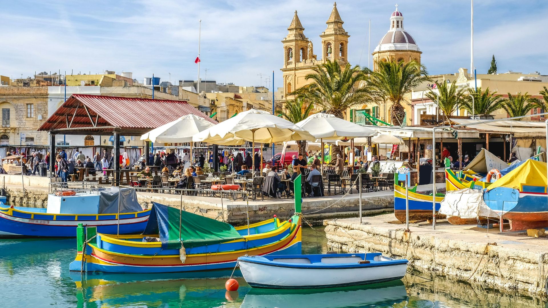blue and yellow boat on water near brown concrete building during daytime