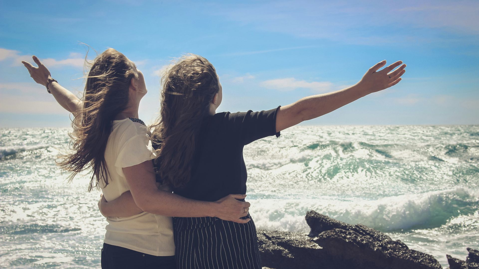 woman in black and white striped dress standing beside woman in white shirt
