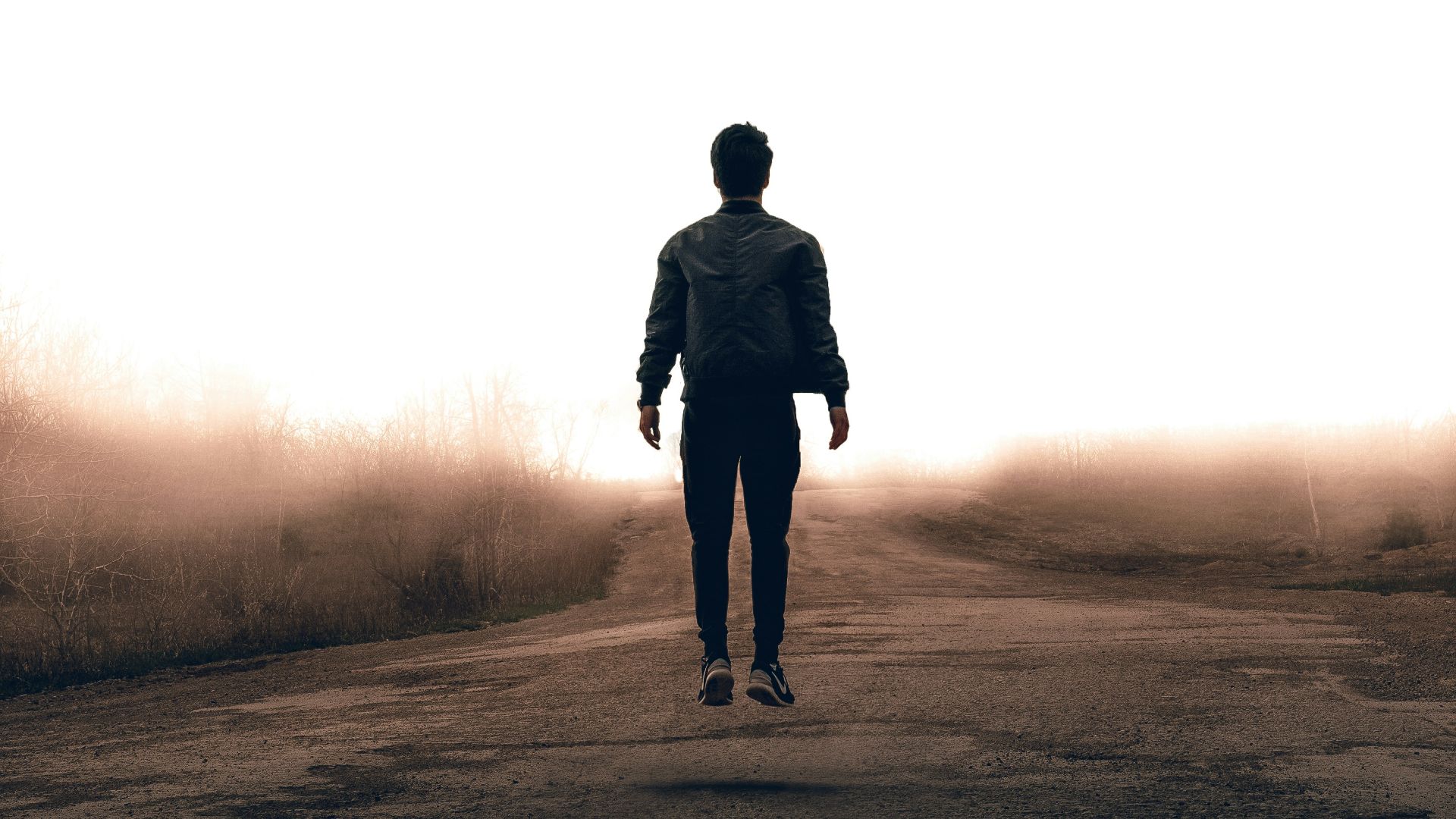man walking along road