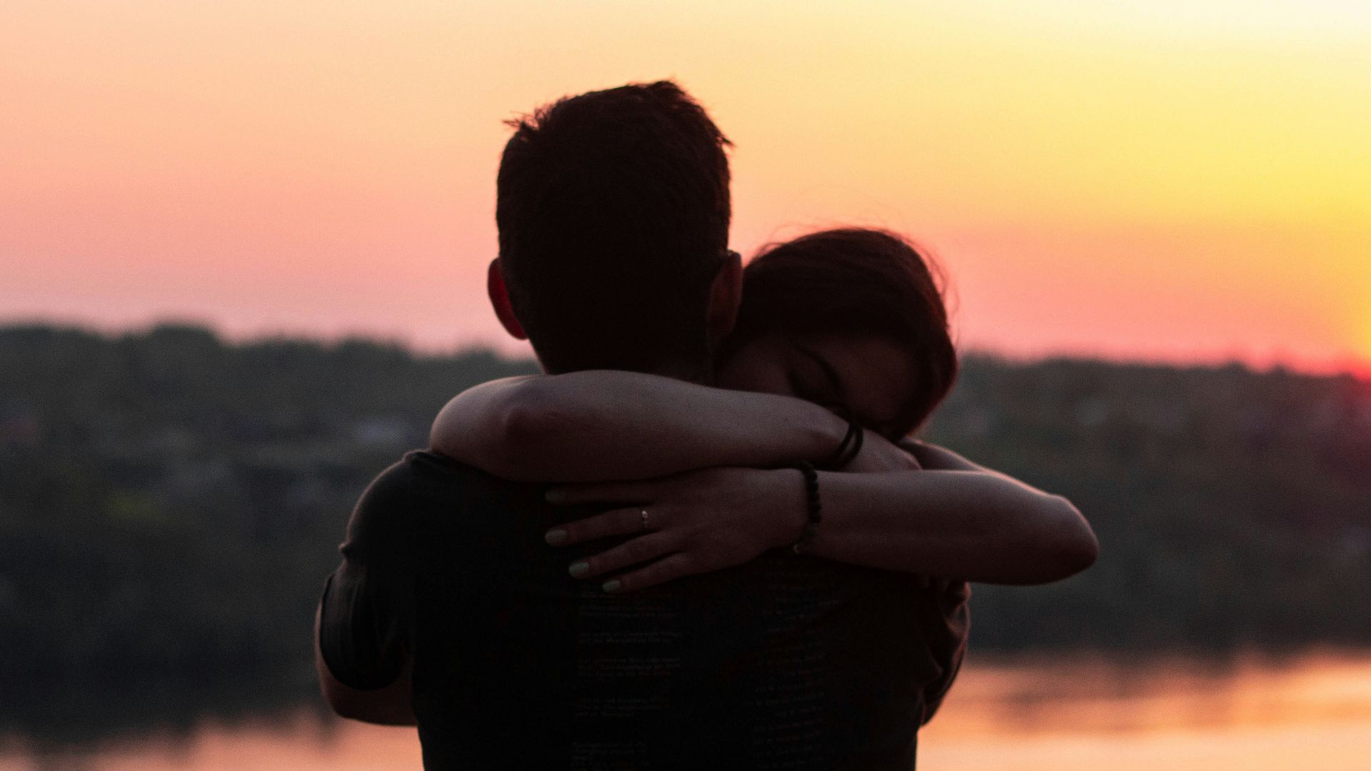 couple hugging each other during sunset