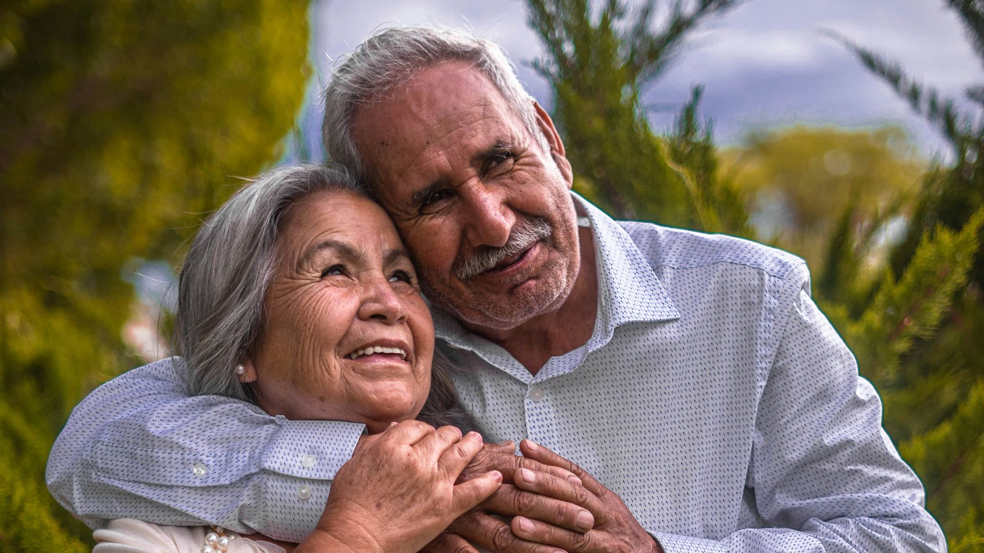 man in white dress shirt hugging woman in white dress