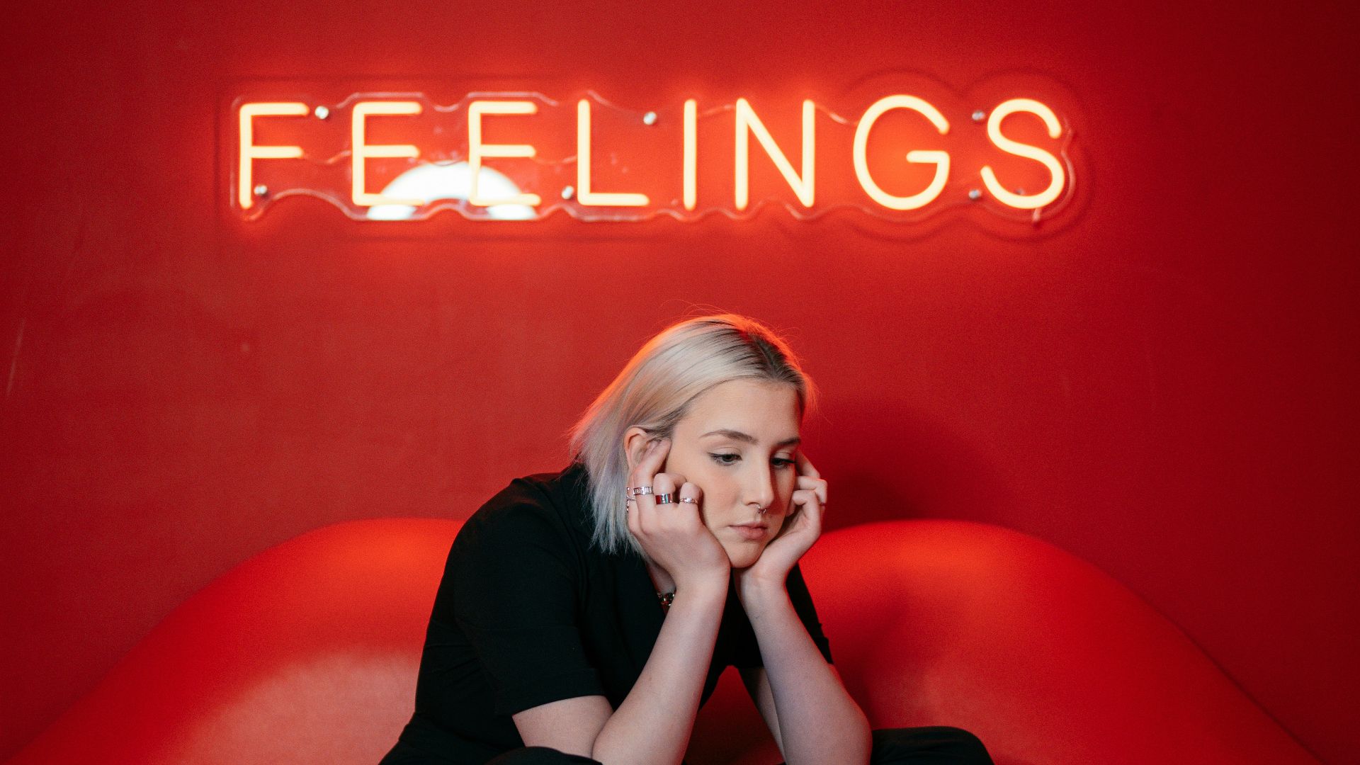 woman in black long sleeve shirt and black pants sitting on red couch