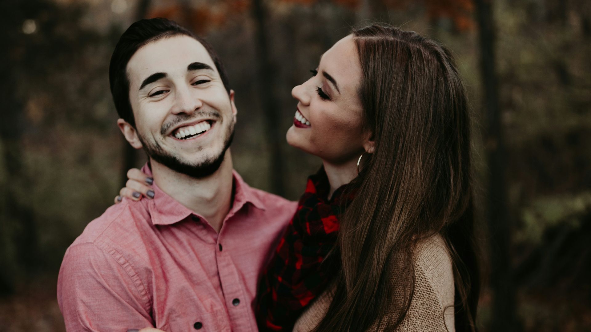 woman hugging man selective focus photography