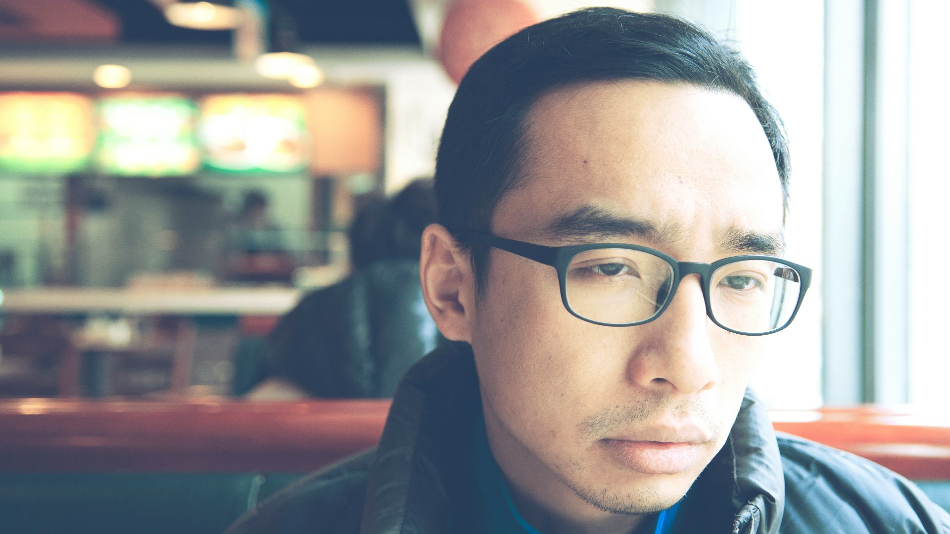 man in black framed eyeglasses and black jacket