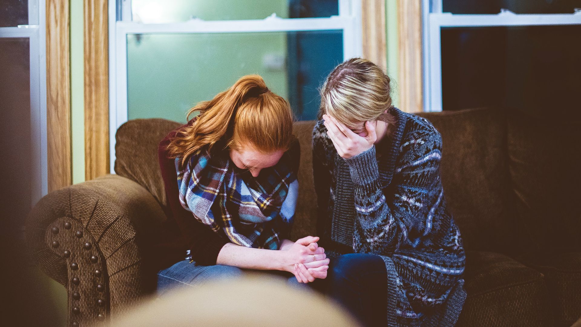 man and woman sitting on sofa in a room