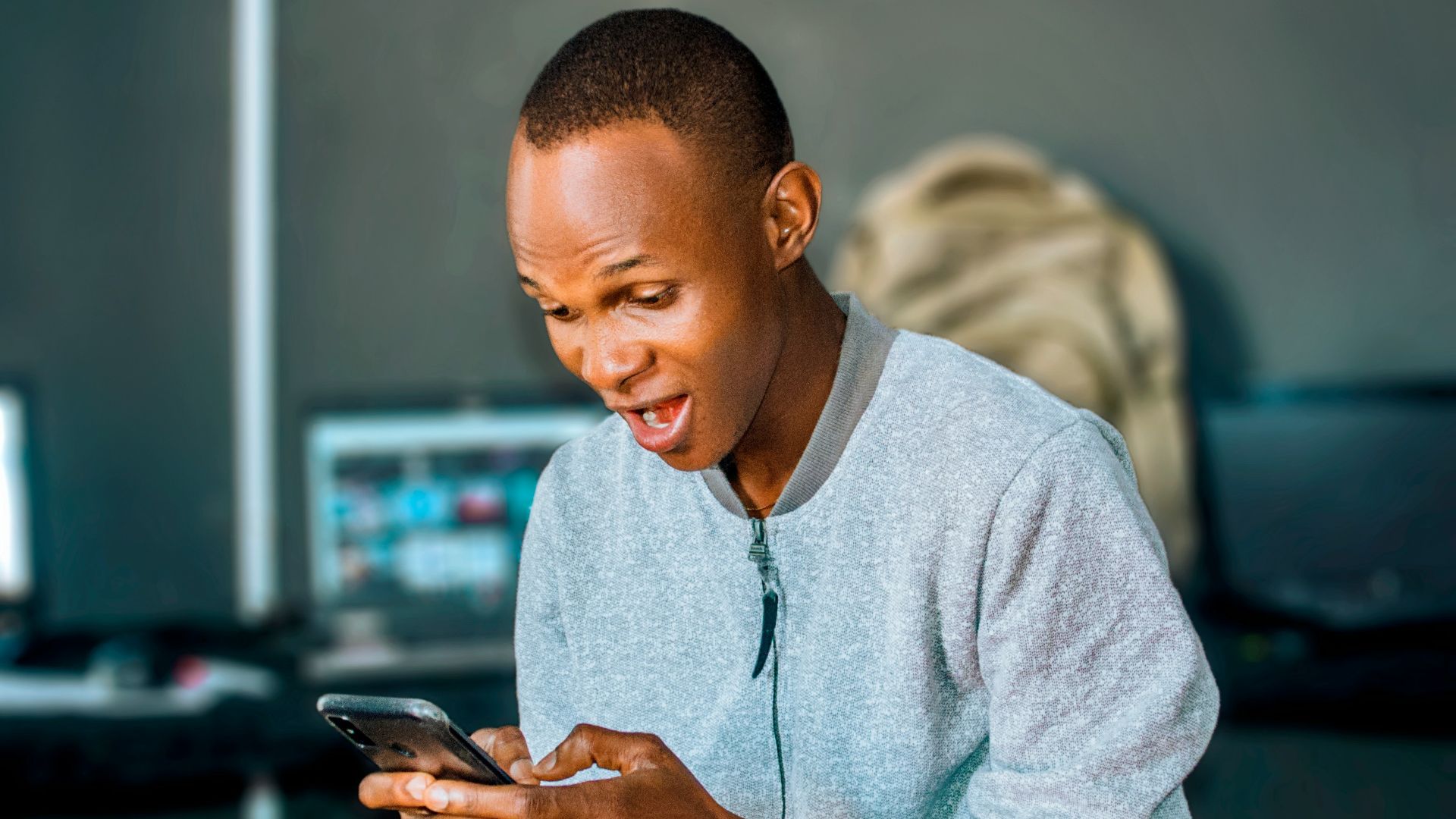 a man looking at his cell phone and laughing