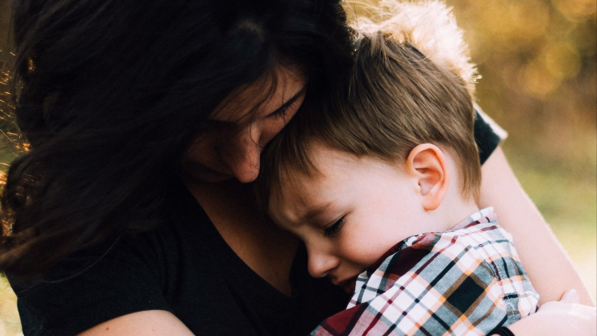 woman hugging boy on her lap