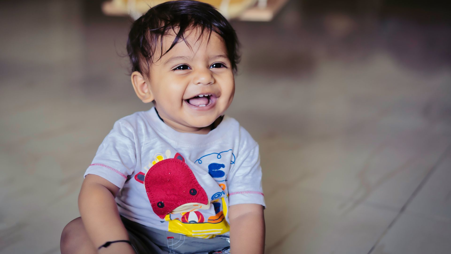 boy in blue and red crew neck t-shirt sitting on yellow and white chair