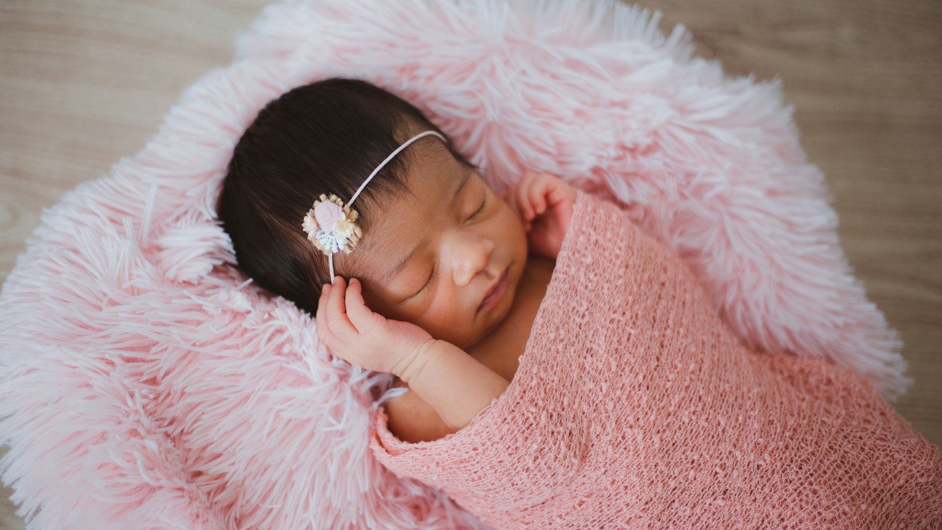 baby sleeping on pink fur pad