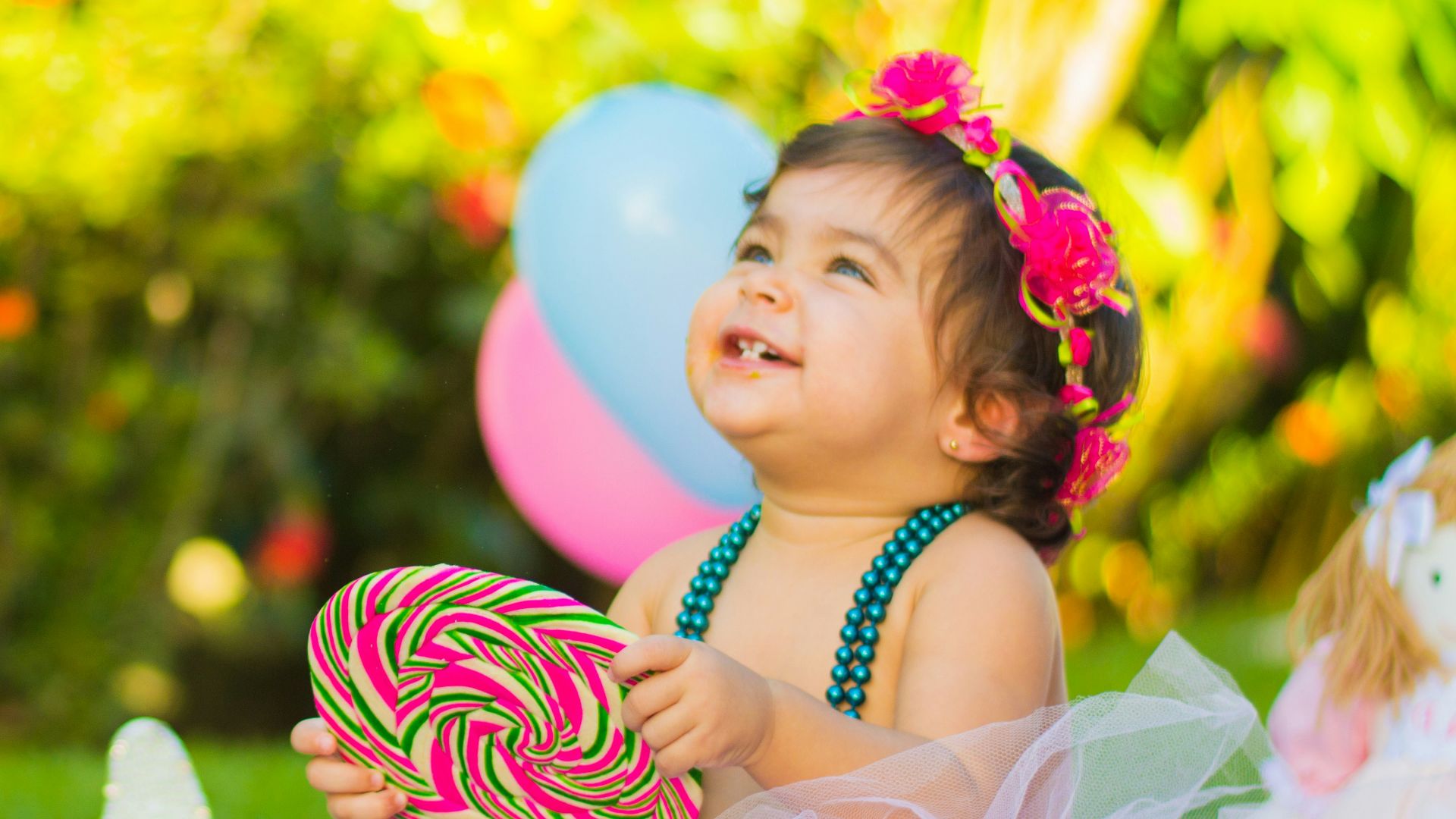 toddler looking up while holding candycane in party
