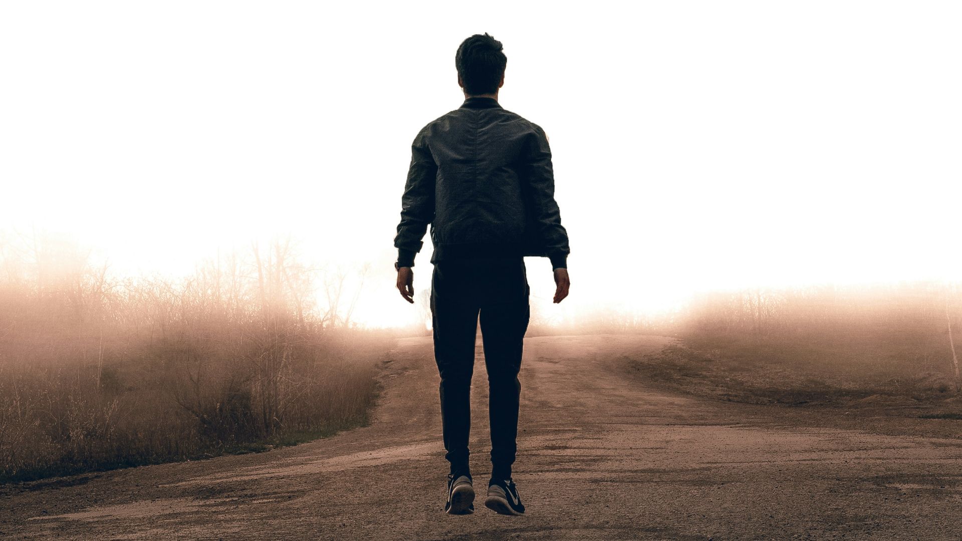 man walking along road