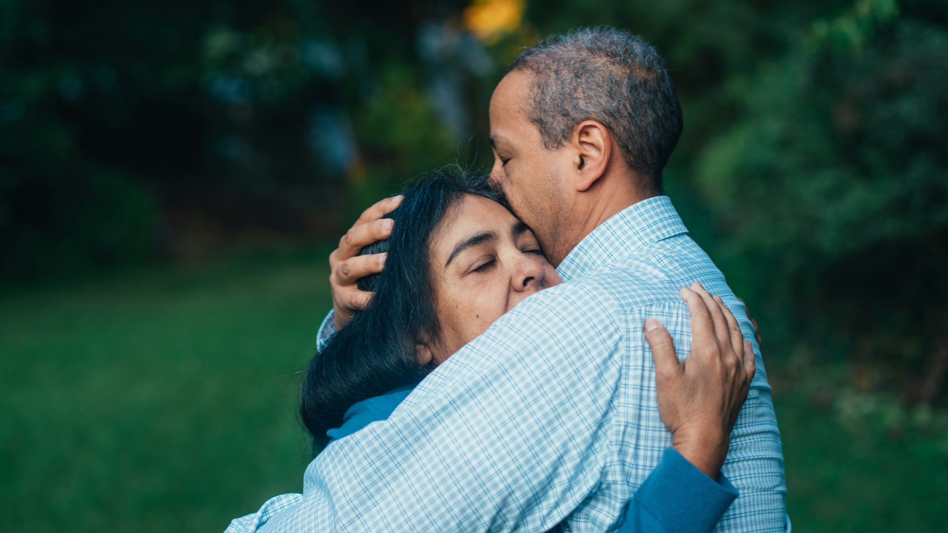 man hugging woman near trees