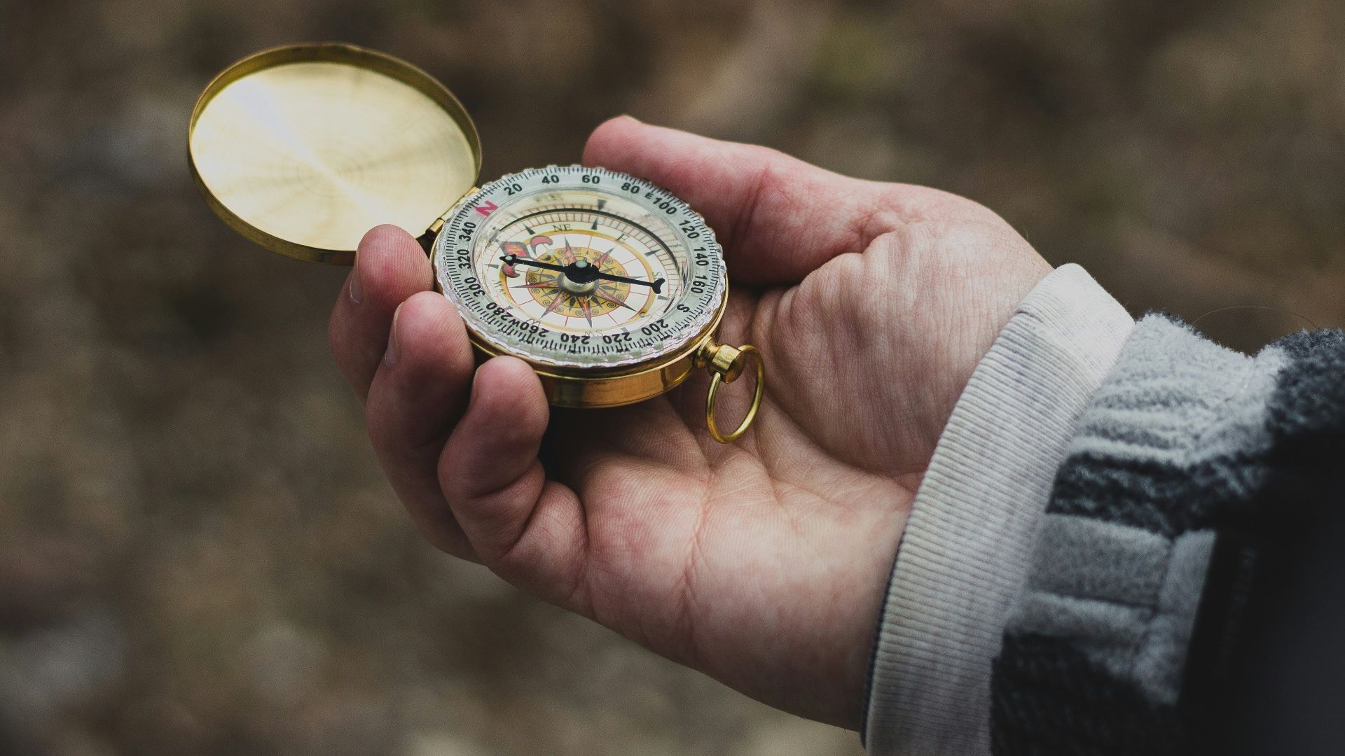 person using white and gold compass
