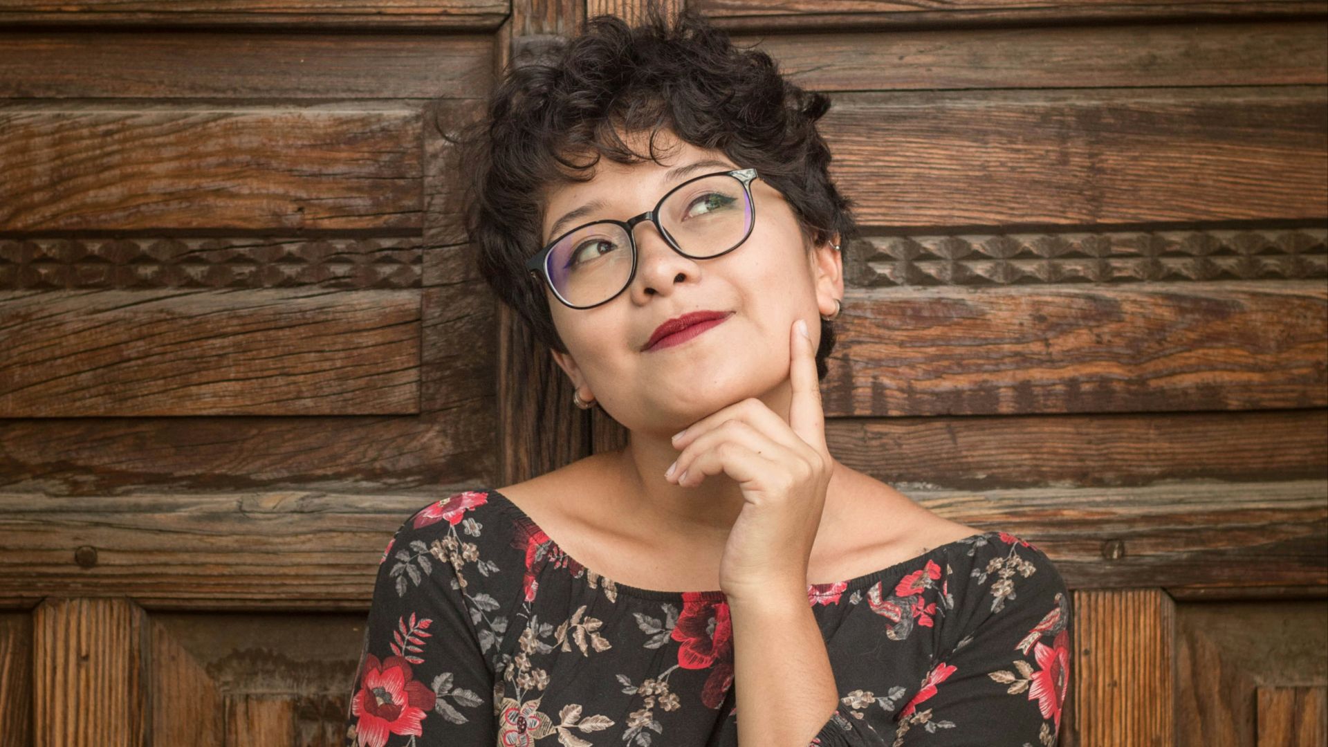 woman leaning against door while holding her cheek