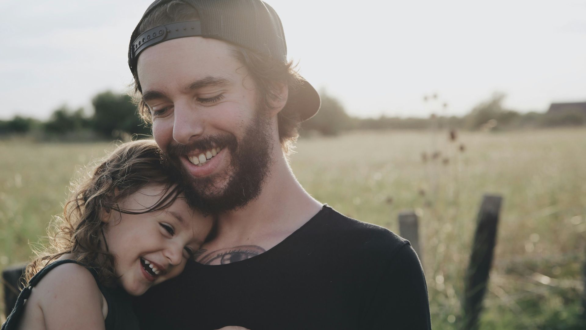 man carrying daughter in black sleeveless top
