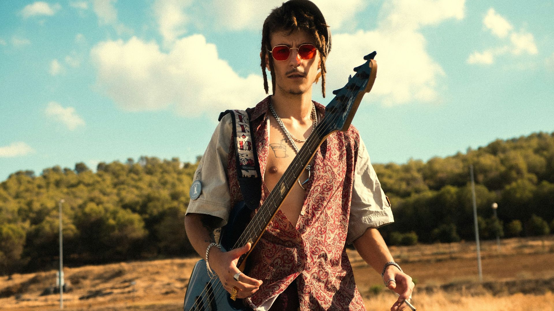 woman in black and white floral dress playing brown electric guitar
