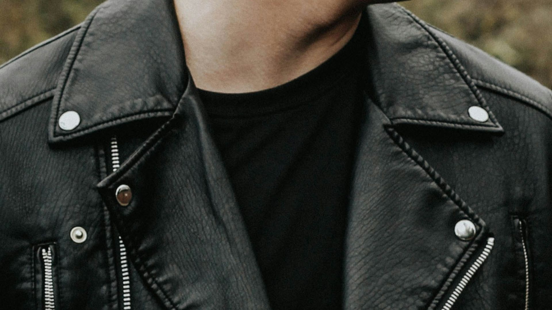 man holding his leather jacket