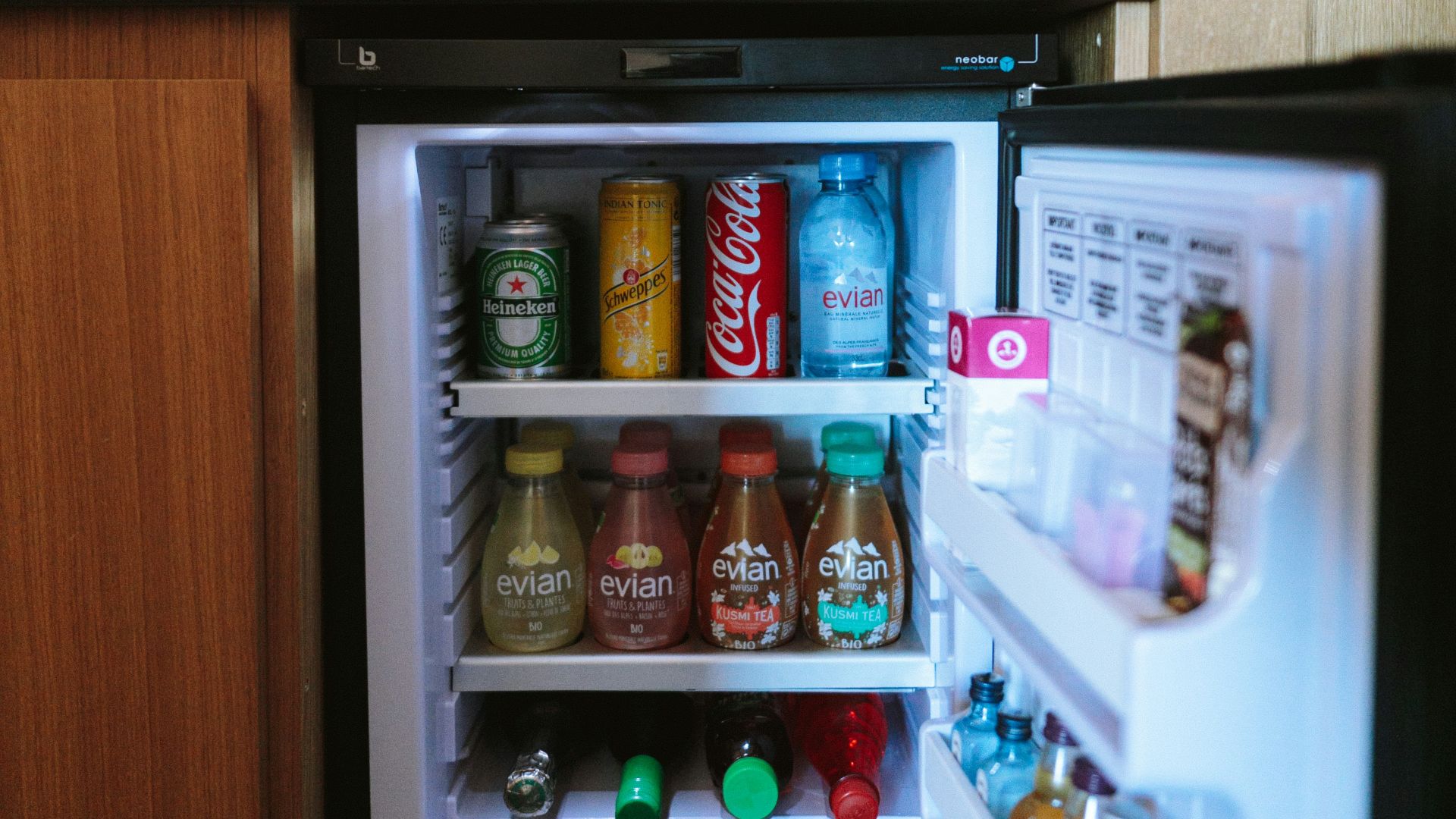 open black compact refrigerator filled with soda bottles
