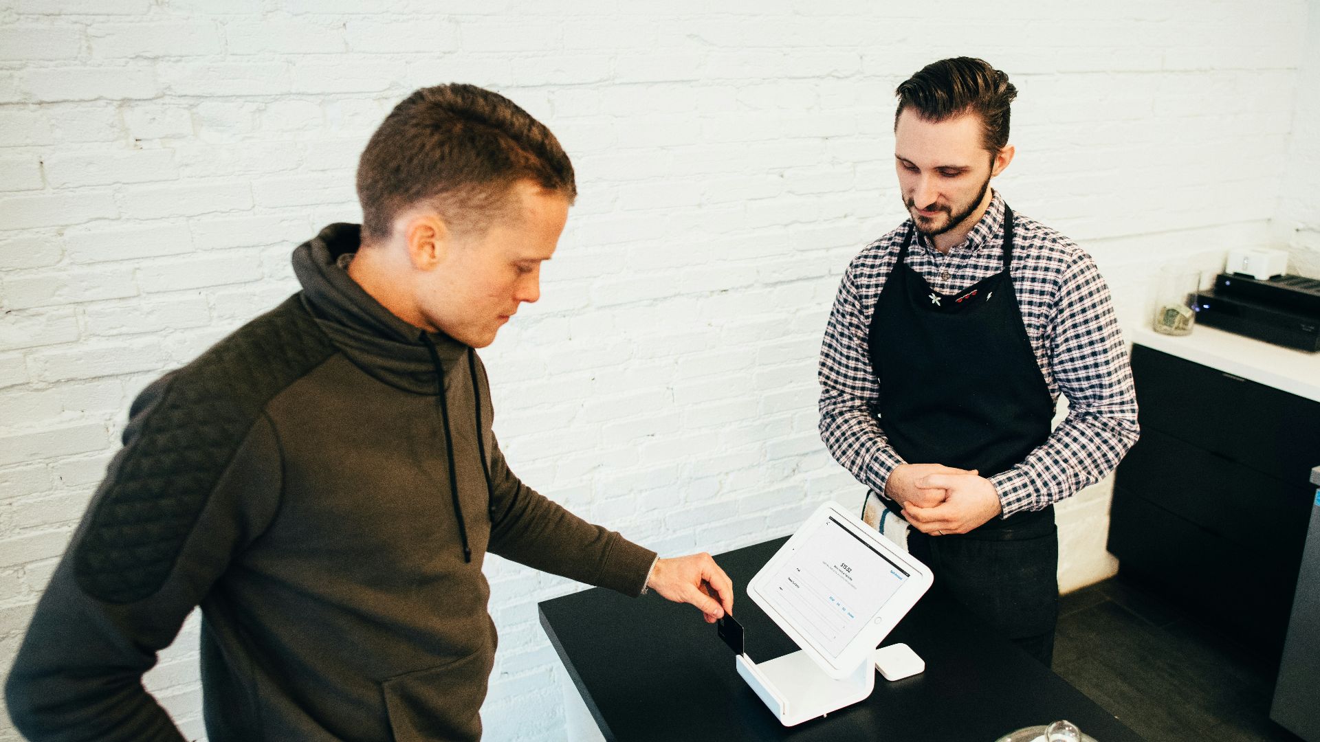 man looking at white digital device