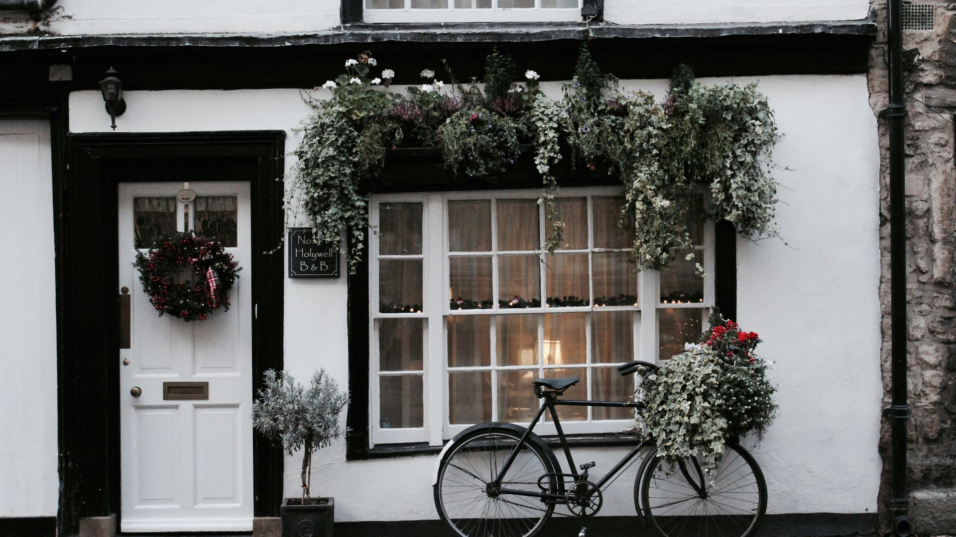 black city bike parked beside white and brown house during daytime