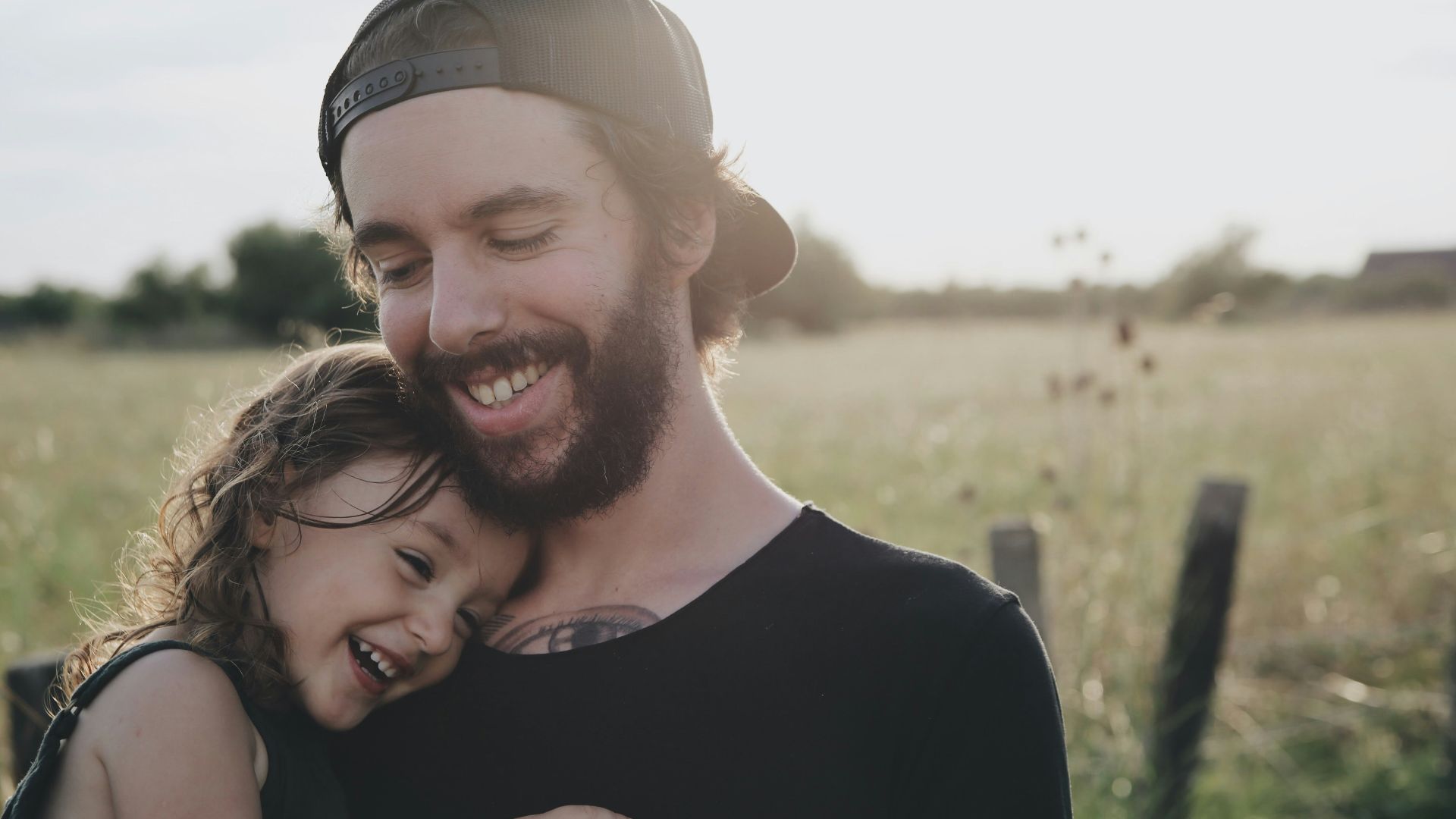 man carrying daughter in black sleeveless top