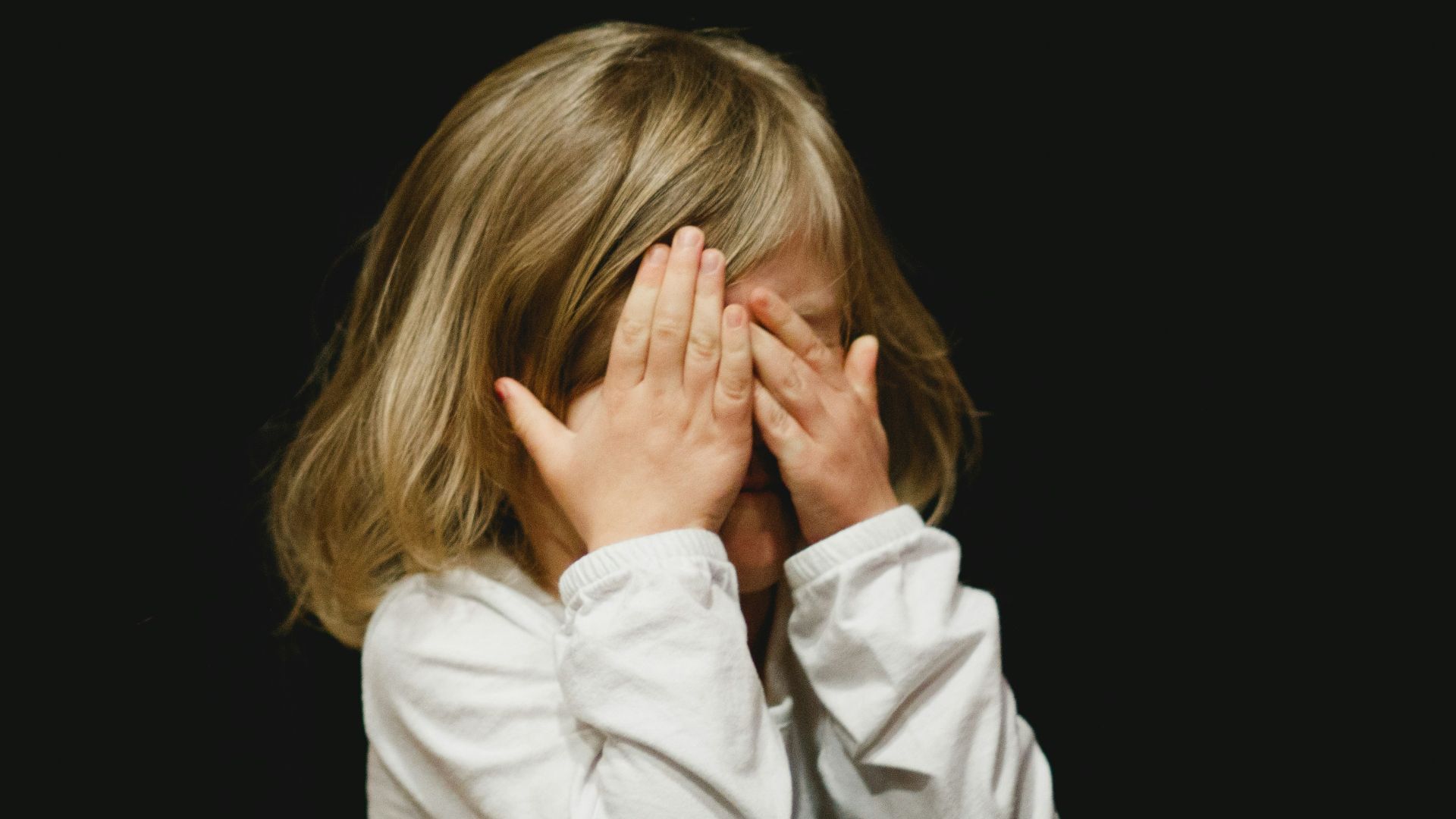 girl covering her face with both hands