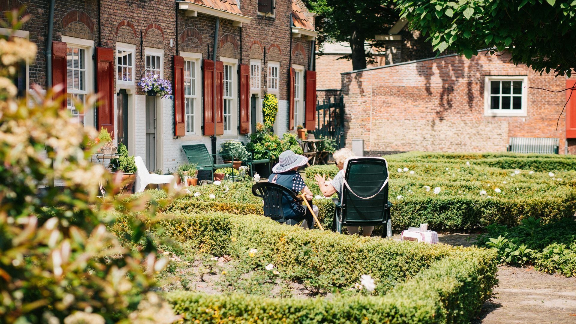 two woman sitting on chair near house at daytime