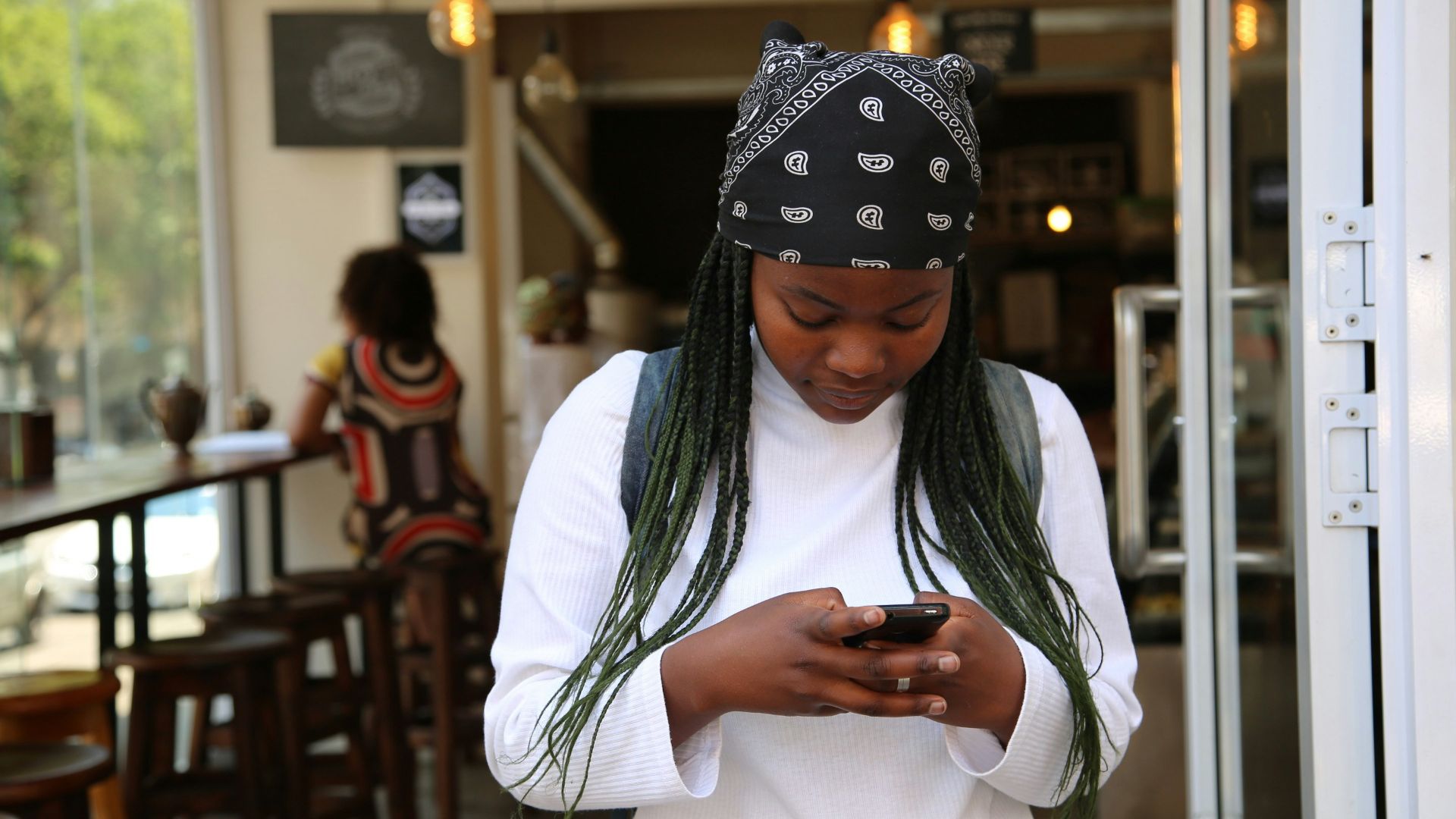 woman standing while holding black phone