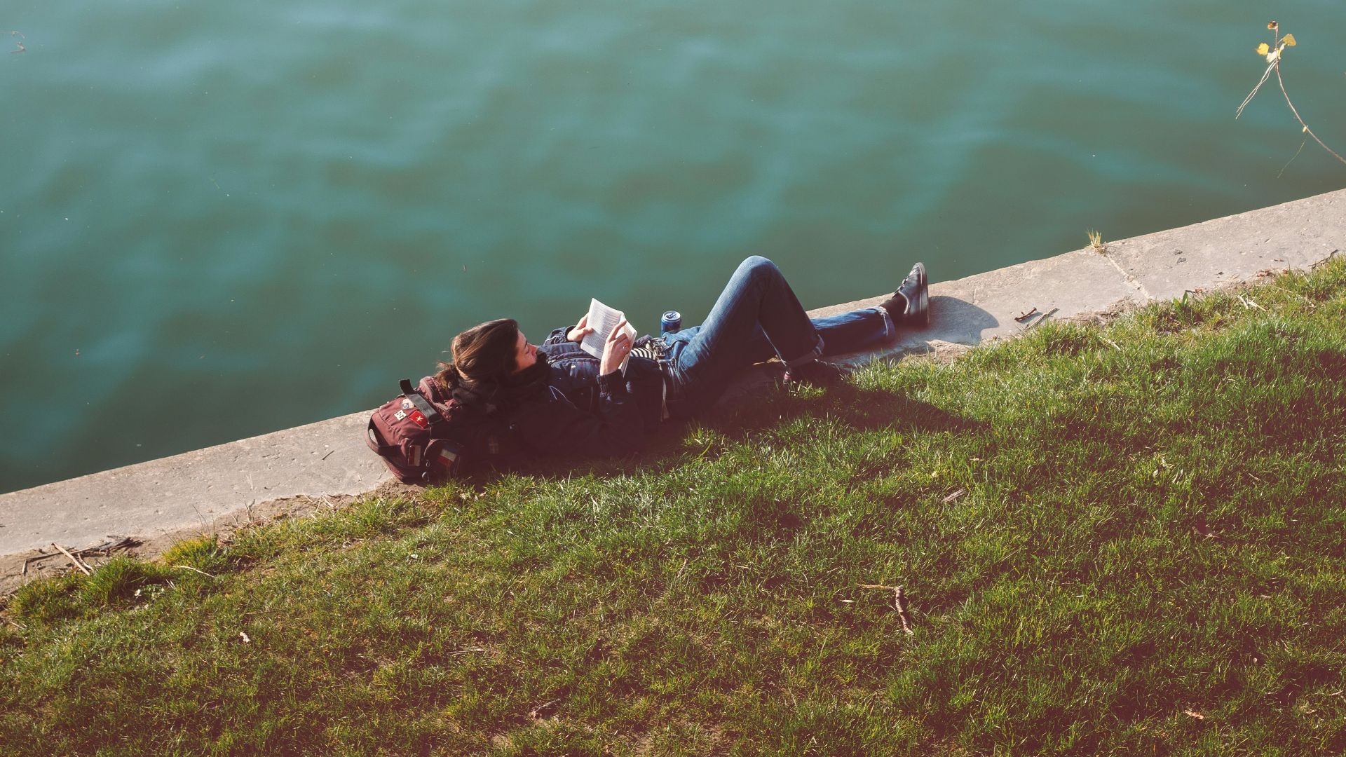 person wearing blue denim jeans lying on the bed